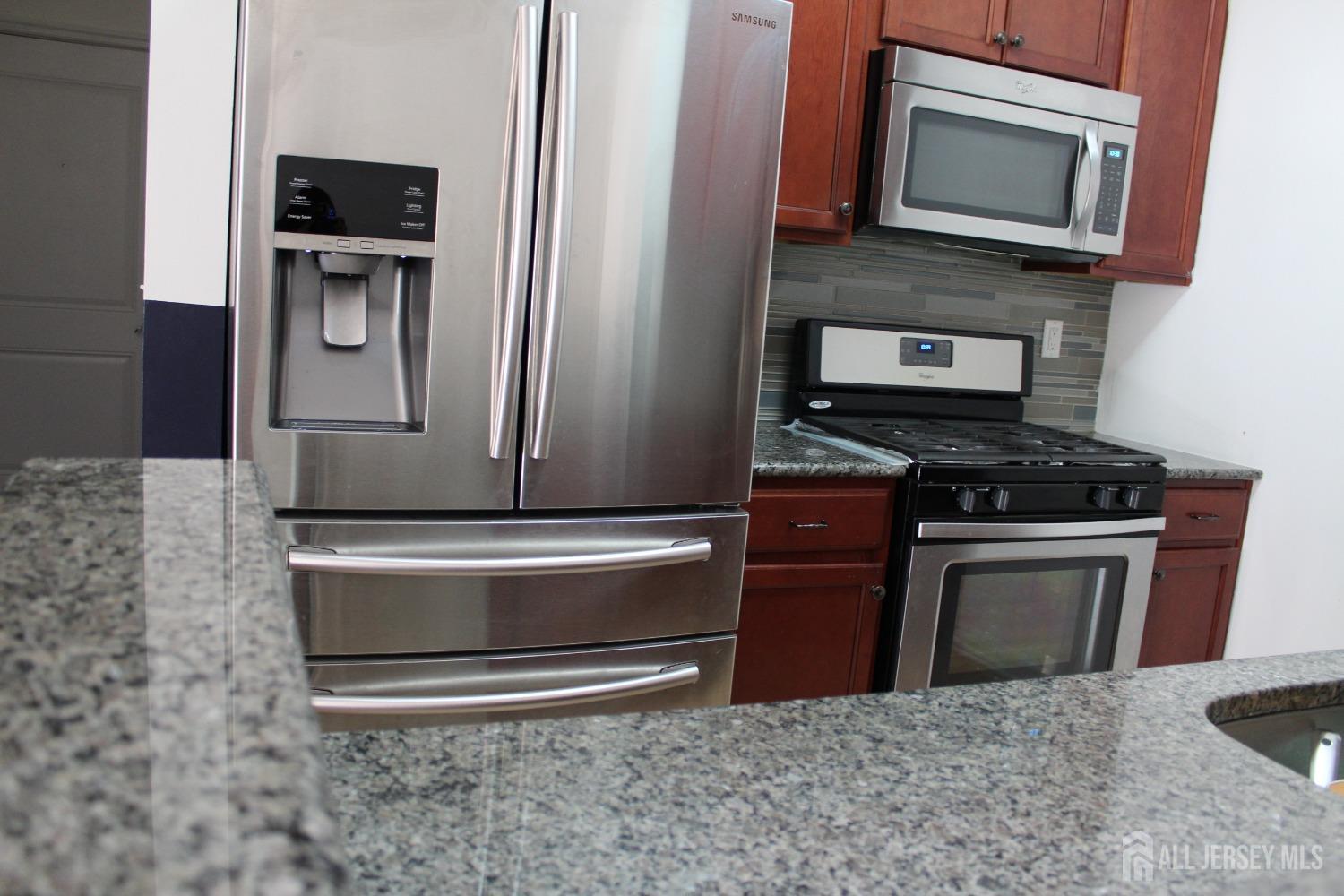 446 Micali Way South Plainfield, NJ 07080 - Photo 7 of 26 a kitchen with granite countertop a stove and a microwave