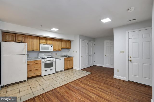 a kitchen with a refrigerator and a stove top oven
