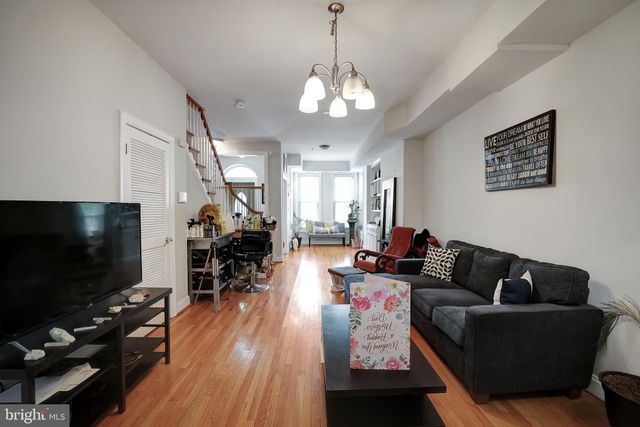 a living room with furniture a flat screen tv and wooden floor