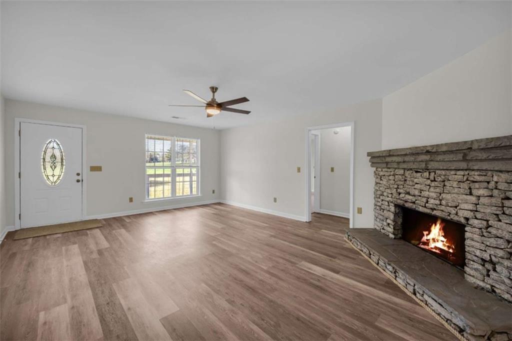 253 Sanders Old Farm Road Crawford, GA 30630 - Photo 14 of 34 a view of empty room with wooden floor and fireplace