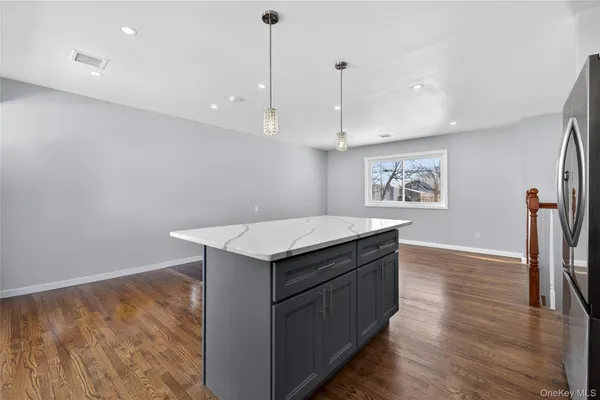 a kitchen with stainless steel appliances granite countertop a sink a refrigerator and wooden floor