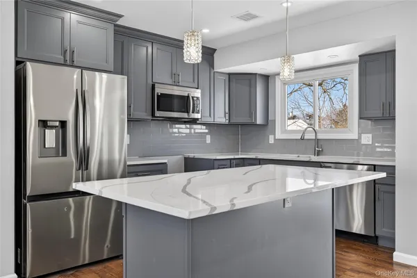 a kitchen with stainless steel appliances a refrigerator sink and microwave