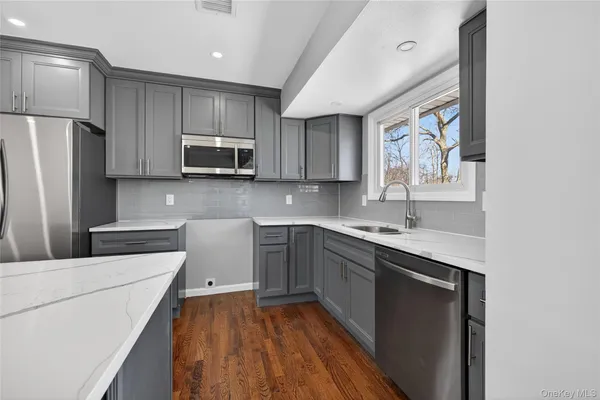 a kitchen with a sink a microwave a refrigerator and cabinets