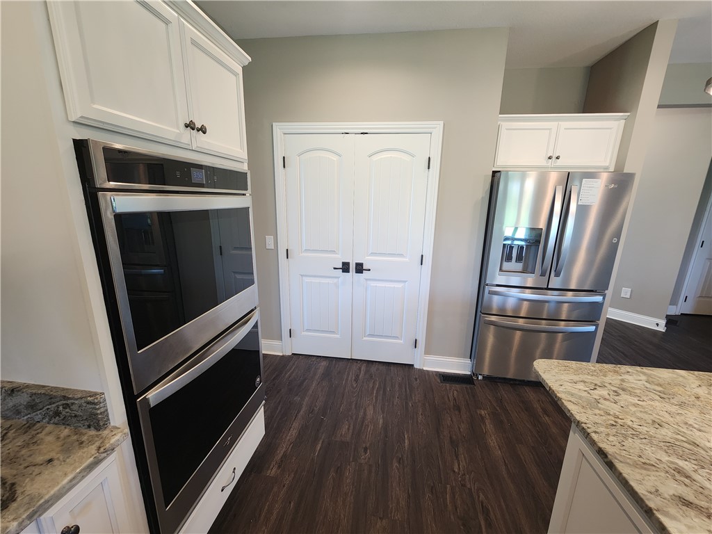 7441 Dodson Road Brookville, OH 45309 - Photo 12 of 50 This modern kitchen offers integrated appliances, granite countertops, and rich wood flooring.