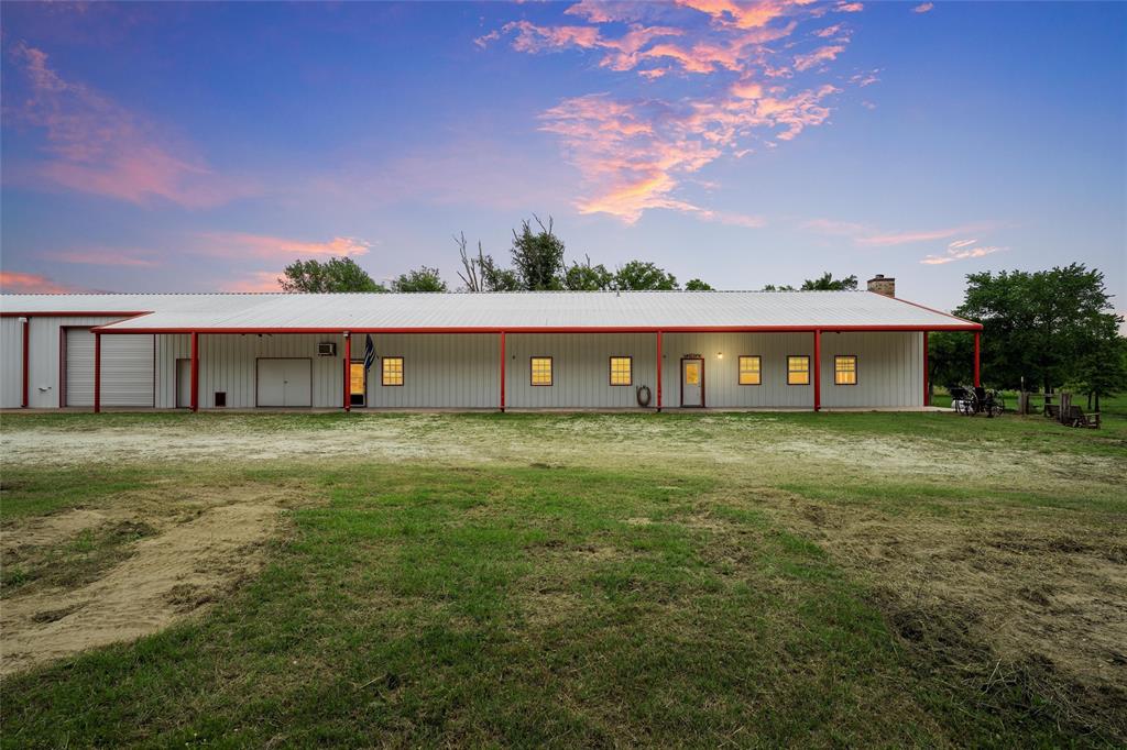 Rear view of property with metal roof, an outbuilding, an outdoor structure, and a garage