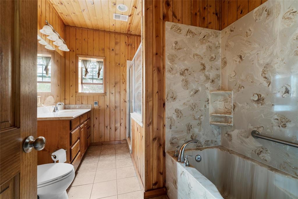237 Lcr 711 Kosse, TX 76653 - Photo 18 of 40 Full bath featuring visible vents, toilet, wooden ceiling, a tub with marble appearance, and vanity