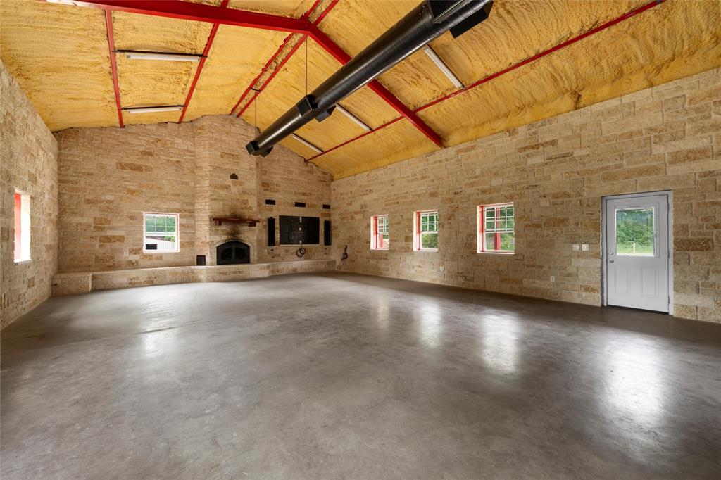 237 Lcr 711 Kosse, TX 76653 - Photo 20 of 40 Unfurnished living room with high vaulted ceiling, finished concrete floors, and a fireplace