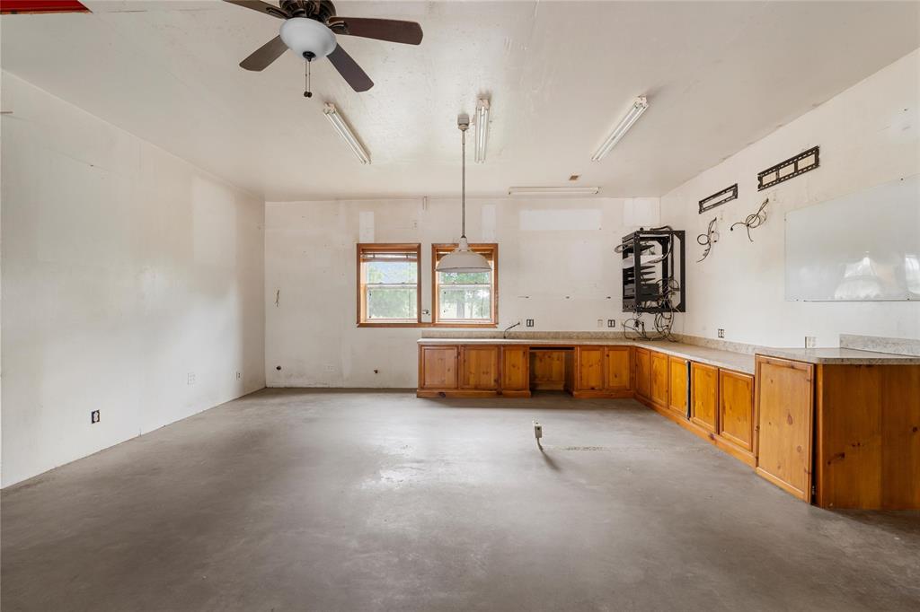 237 Lcr 711 Kosse, TX 76653 - Photo 8 of 40 Kitchen with concrete floors, a ceiling fan, hanging light fixtures, brown cabinets, and light countertops