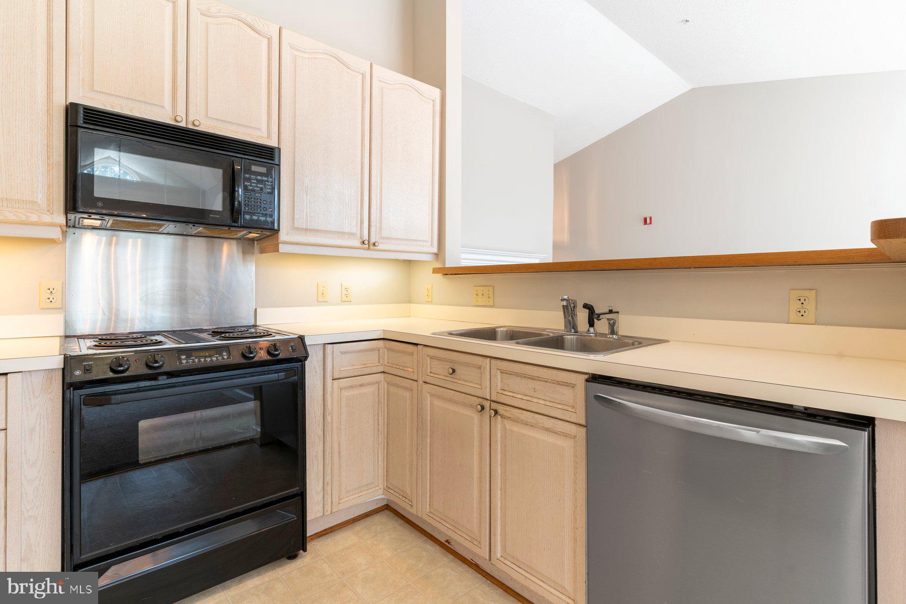 533 Runabout Loop, Unit 533 Solomons, MD 20688 - Photo 13 of 29 a kitchen with stainless steel appliances granite countertop a sink stove and microwave