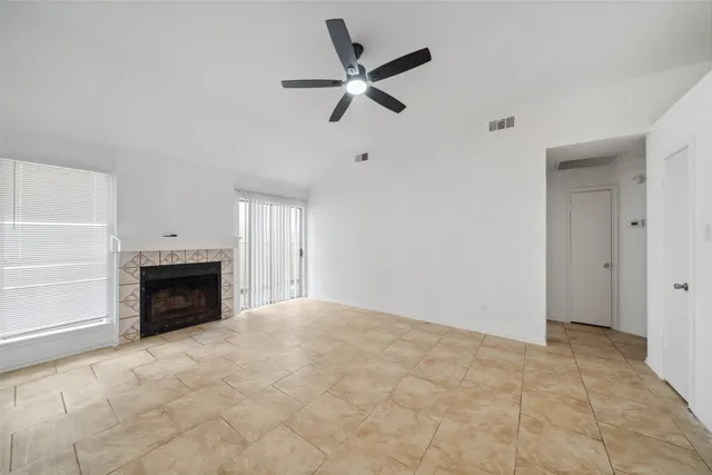 a view of an empty room with a fireplace and a window