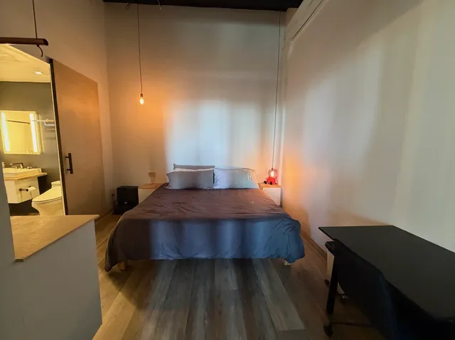 a bedroom with a bed and wooden floor