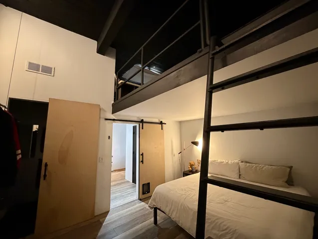 a bedroom with a bed and wooden floor