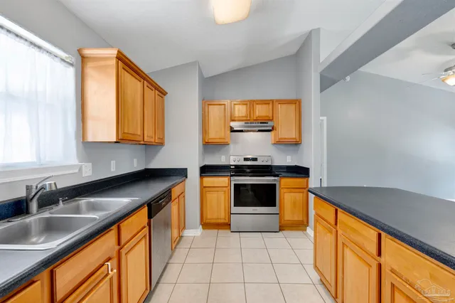 a kitchen with stainless steel appliances granite countertop a sink and a stove