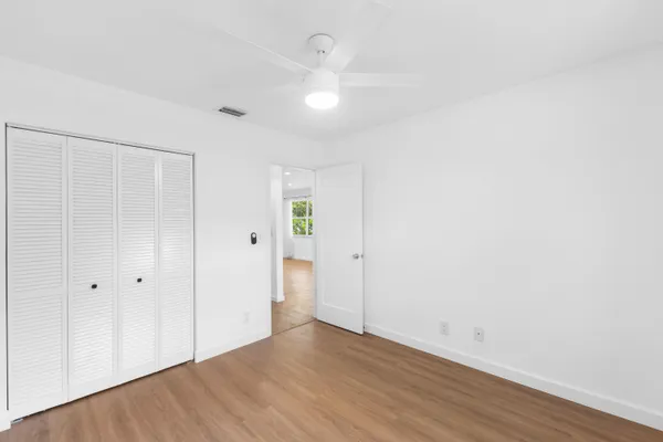 a view of an empty room with wooden floor