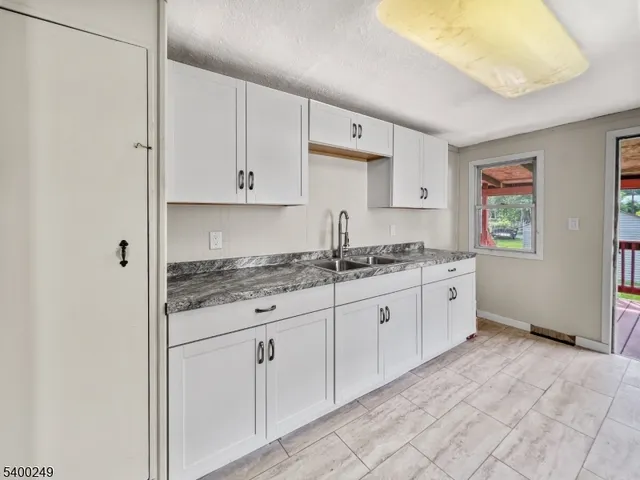 a kitchen with granite countertop white cabinets and white appliances