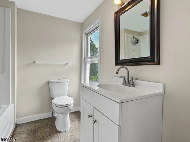 a bathroom with a toilet sink and mirror