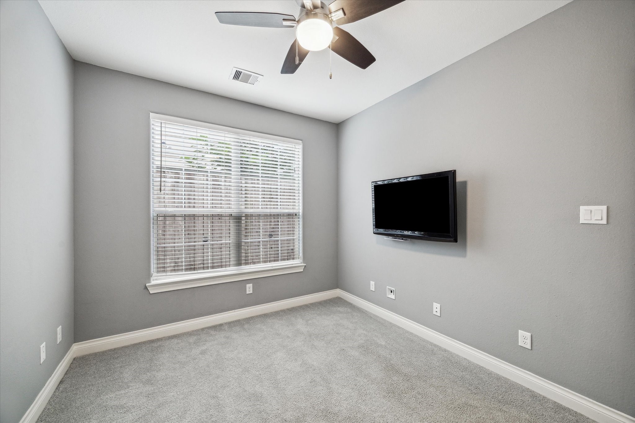 3432 Cline Street Houston, TX 77020 - Photo 12 of 22 a view of a livingroom with a flat screen tv window and a ceiling fan