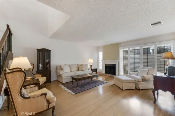 a living room with furniture a fireplace and a floor to ceiling window