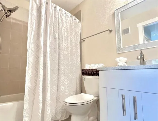 a bathroom with a sink a toilet and shower curtain