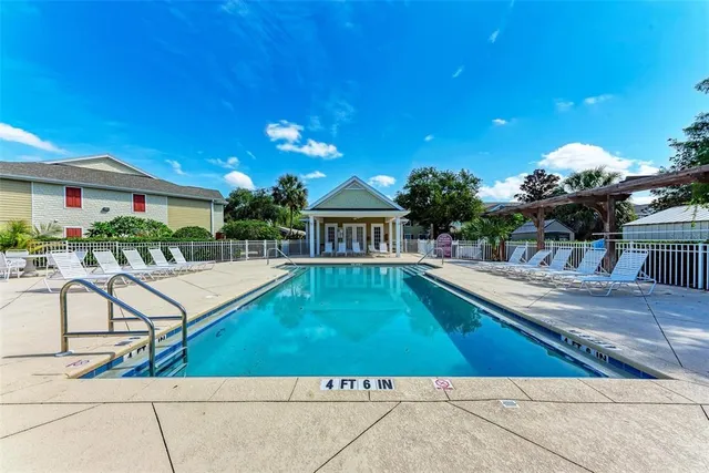 a view of house with swimming pool and sitting area