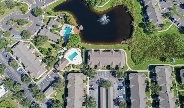 an aerial view of a house with a yard and large trees