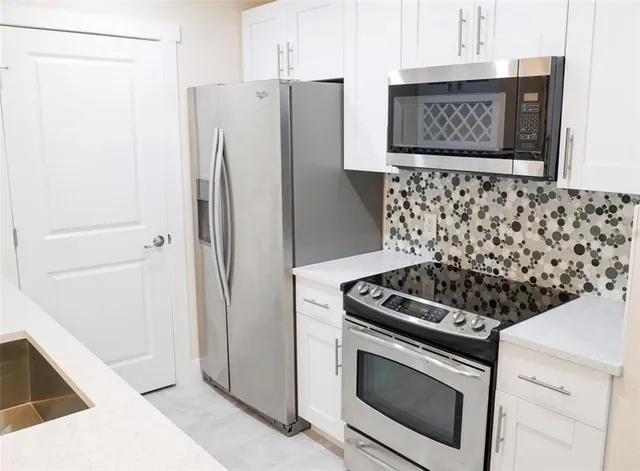 a kitchen with stainless steel appliances a refrigerator and a stove