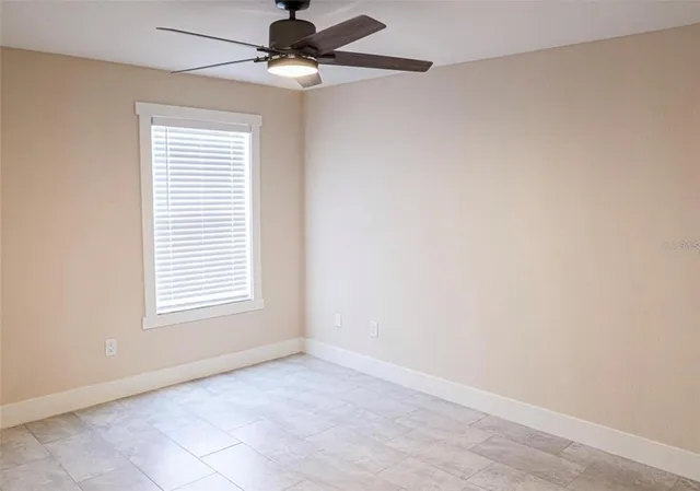 an empty room with windows and fan