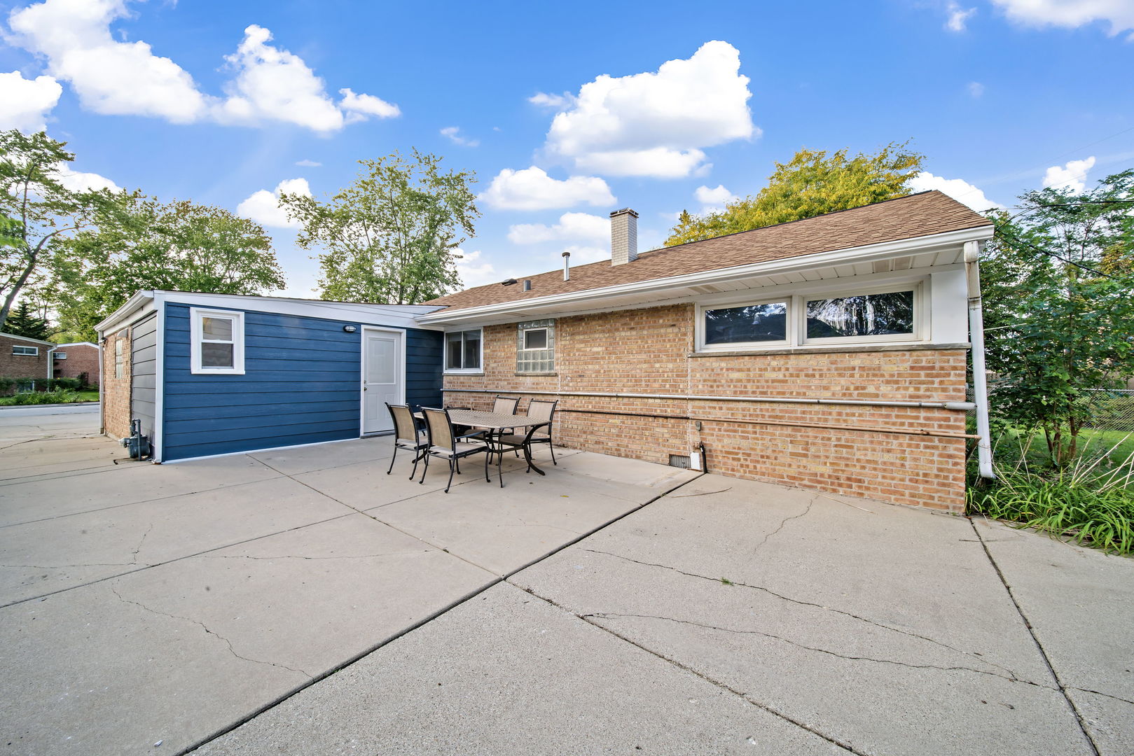 405 Marshall Road Northbrook, IL 60062 - Photo 23 of 27 a backyard of a house with table and chairs with plants and wooden fence