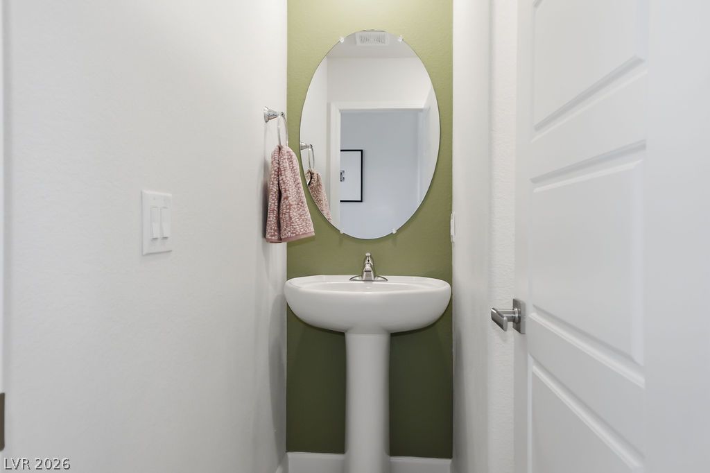 913 Cadence View Way Henderson, NV 89011 - Photo 23 of 46 A chic pedestal sink elevates this compact bathroom with sophisticated simplicity.