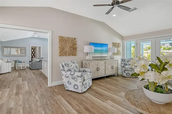 a living room with furniture a large window and stainless steel appliances