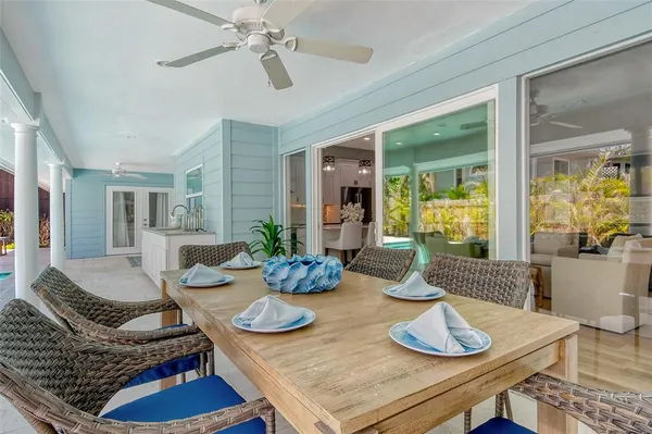 a large kitchen with granite countertop a sink dishwasher a stove and a dining table with wooden floor
