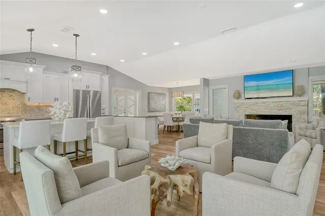 a living room with furniture a fireplace and a chandelier