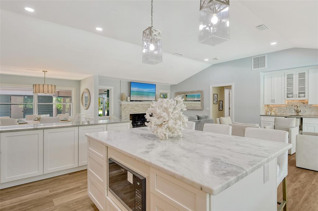 4852 Featherbed Lane Sarasota, FL 34242 - Photo 29 of 79 a large kitchen with granite countertop a sink dishwasher a stove and a dining table with wooden floor