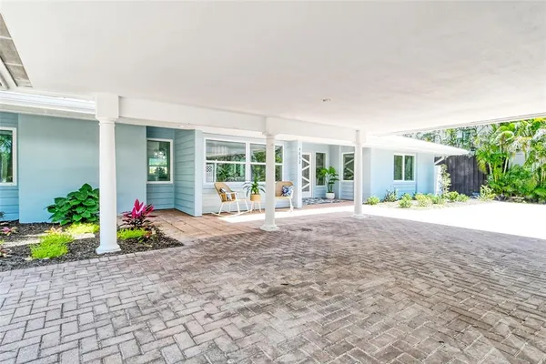 a large living room with stainless steel appliances granite countertop lots of white cabinets a couch and wooden floor