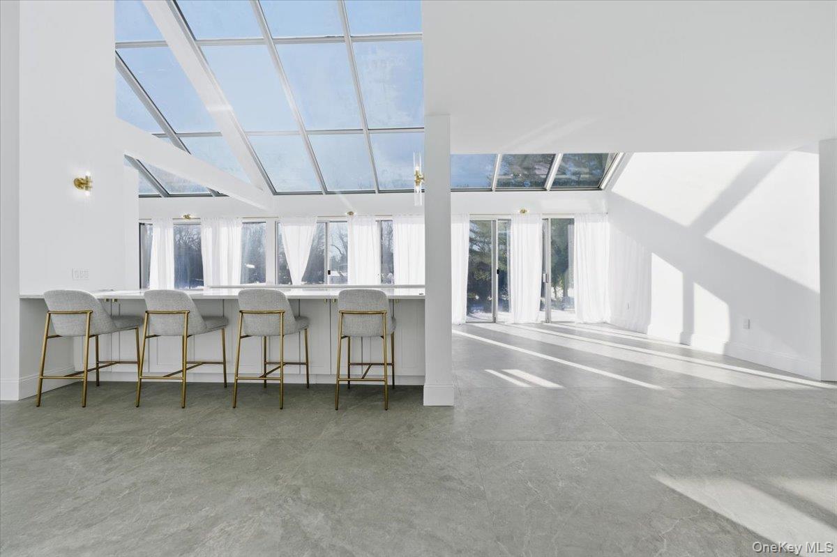 454 East Shore Road Great Neck, NY 11024 - Photo 12 of 42 a room with lots of white furniture and a chandelier