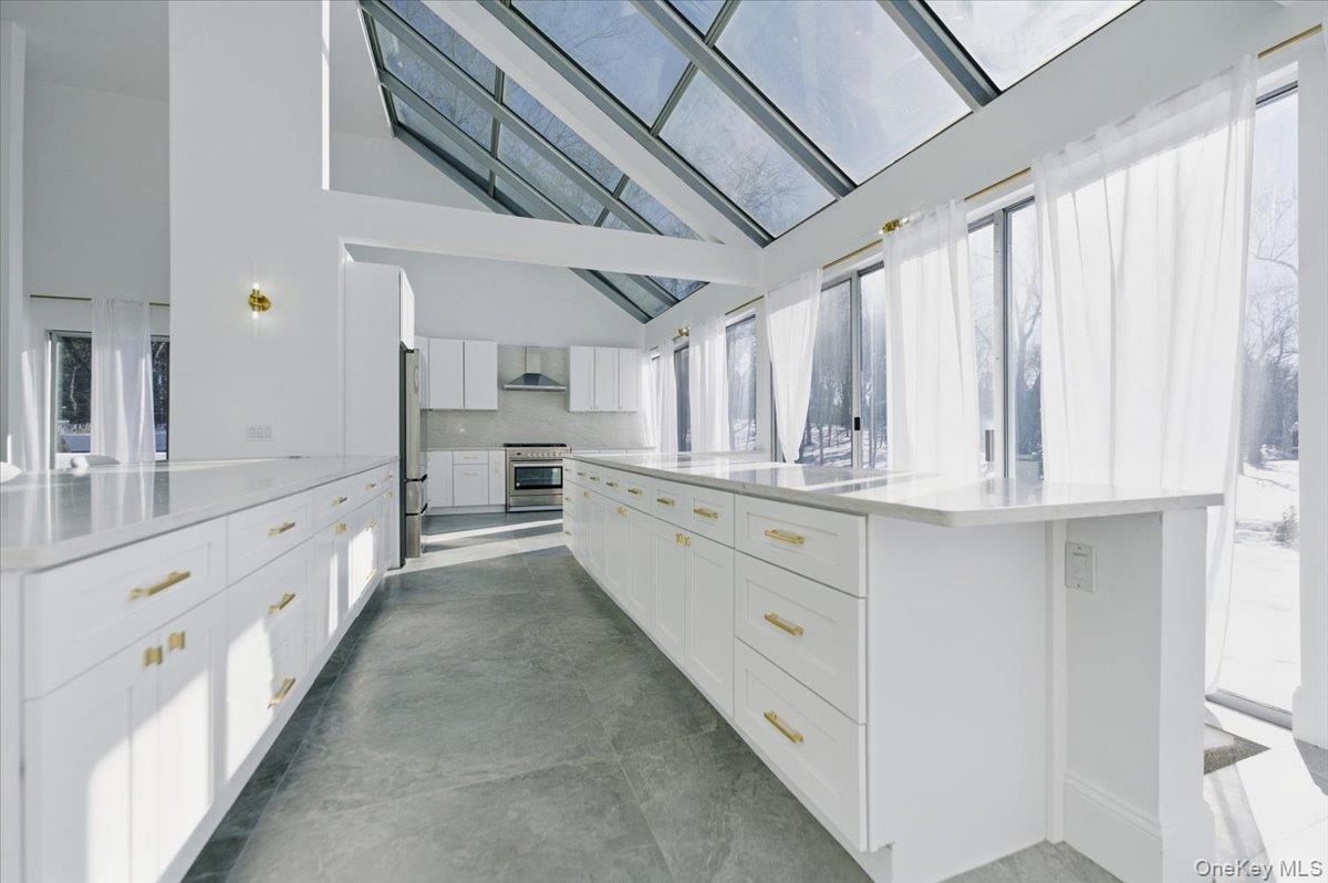 454 East Shore Road Great Neck, NY 11024 - Photo 14 of 42 a large white kitchen with granite countertop a sink