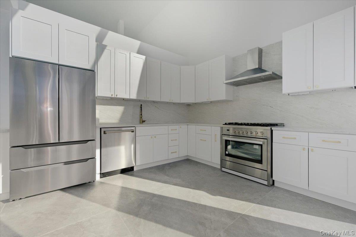 454 East Shore Road Great Neck, NY 11024 - Photo 17 of 48 a kitchen with cabinets and stainless steel appliances