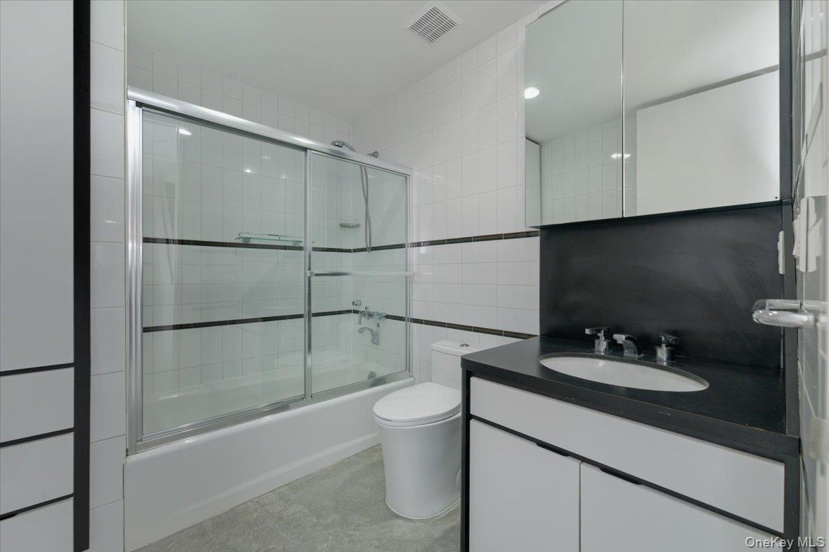 454 East Shore Road Great Neck, NY 11024 - Photo 18 of 42 a bathroom with a sink a toilet and shower