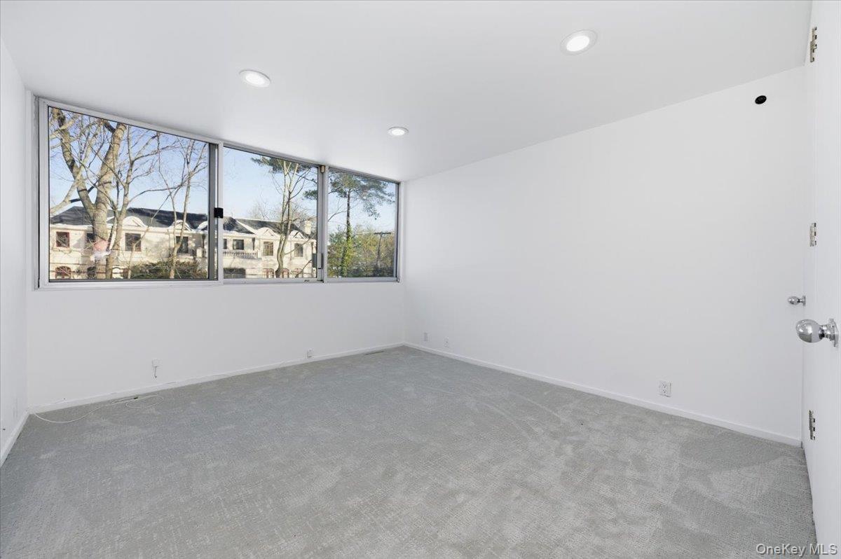 454 East Shore Road Great Neck, NY 11024 - Photo 26 of 48 an empty room with windows and entrance