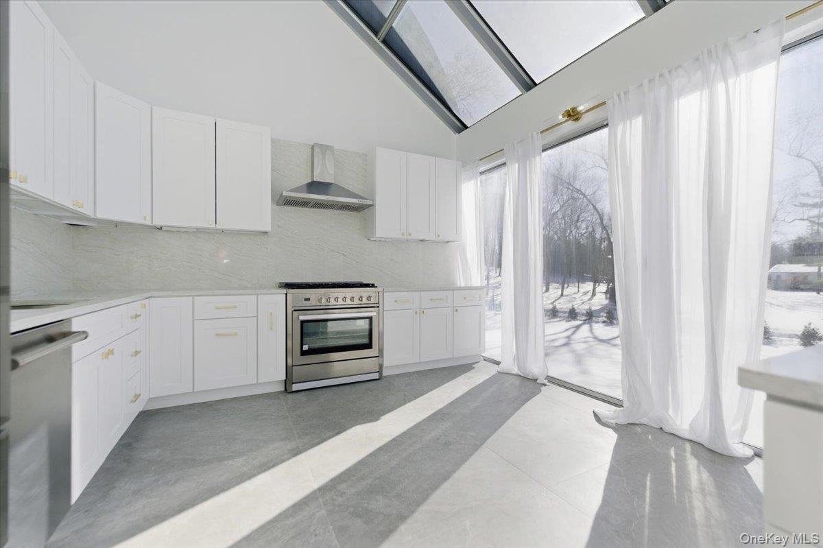 454 East Shore Road Great Neck, NY 11024 - Photo 9 of 42 a kitchen with stainless steel appliances a stove and a refrigerator