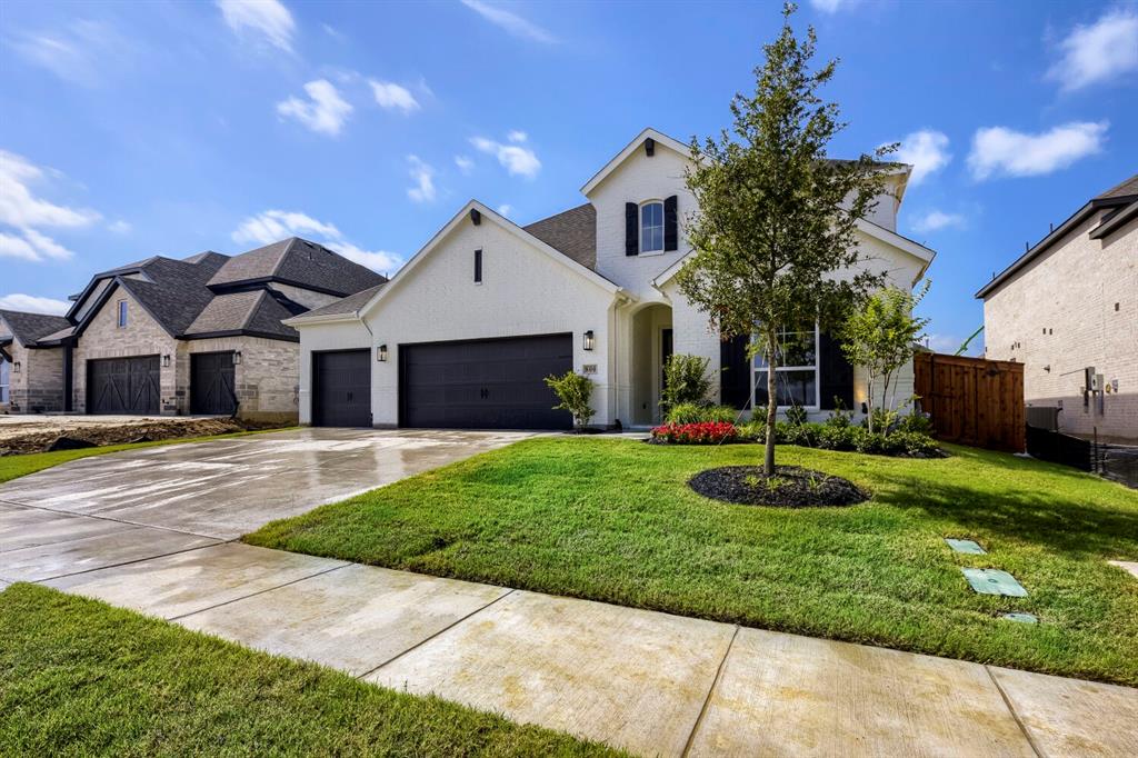 800 Blackberry Road Haslet, TX 76052 - Photo 28 of 28 Modern white brick residence featuring a dark gray roof, black garage doors, and a manicured lawn