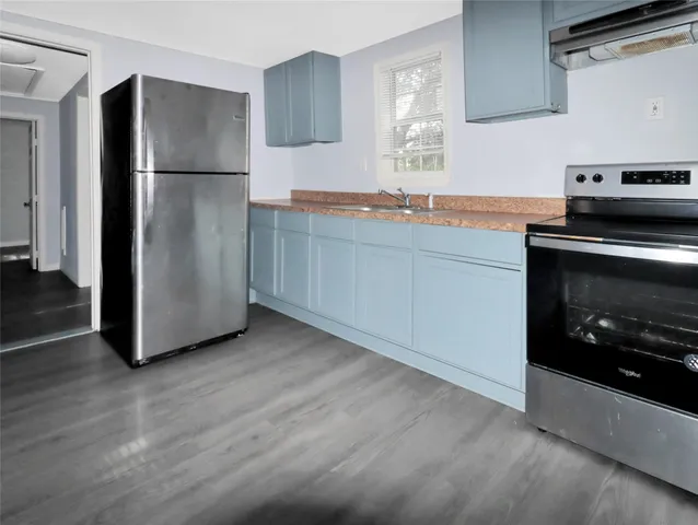 a kitchen with stainless steel appliances granite countertop a refrigerator a stove a sink and a microwave