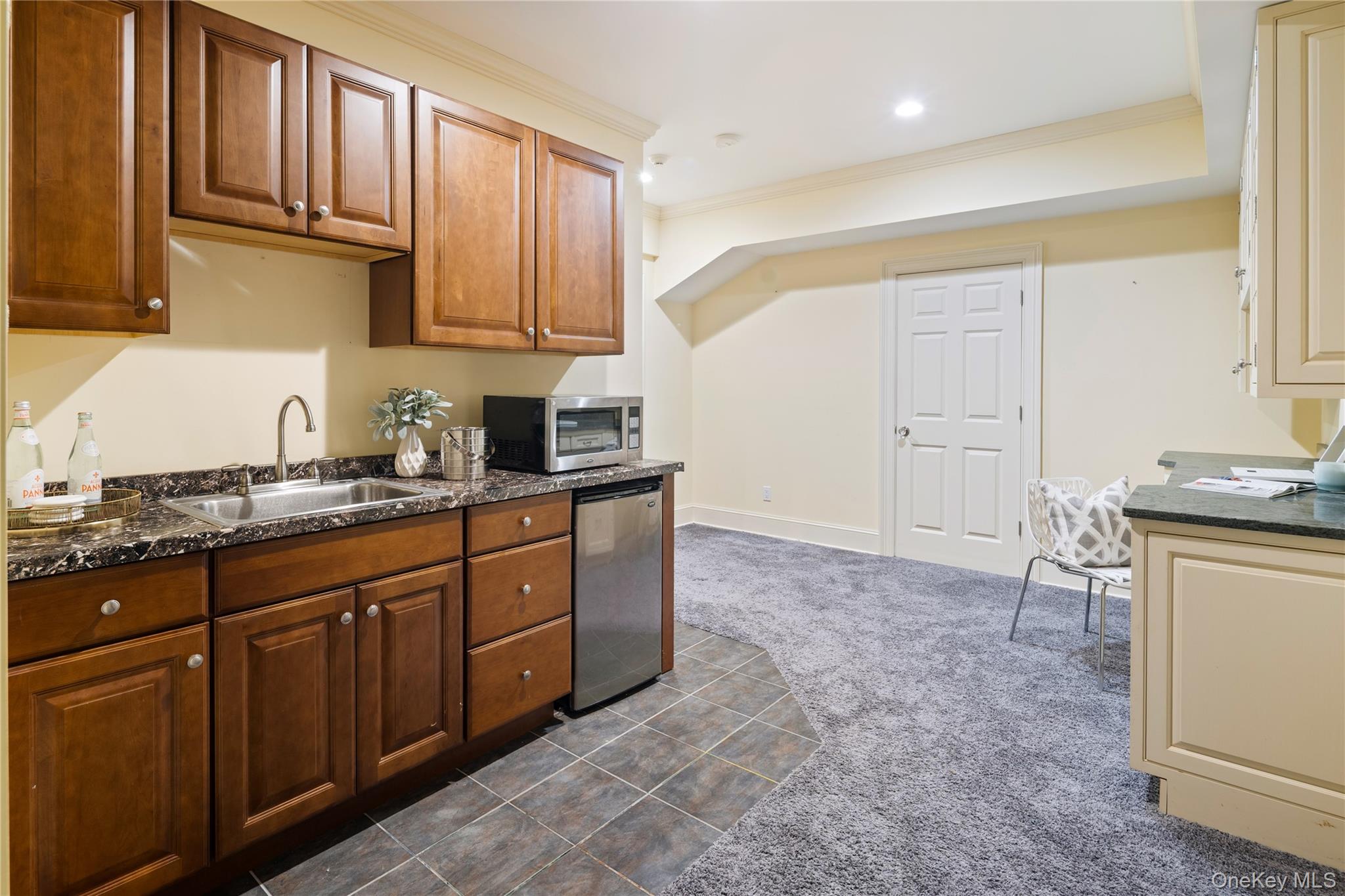 77 Byram Ridge Road Armonk, NY 10504 - Photo 41 of 48 Lower level wet bar with sink, beverage refrigerator and microwave, addtional storage cabinetry with granite counters on opposite wall