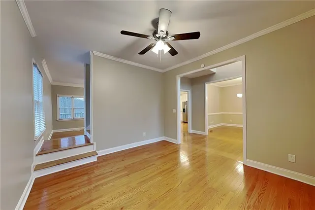 a view of an empty room with window and wooden floor