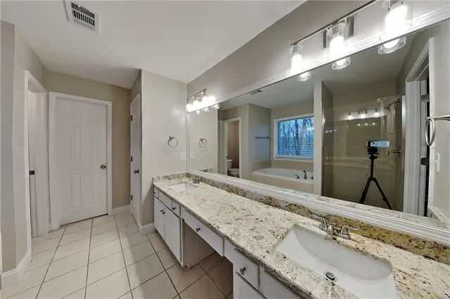 a spacious bathroom with a granite countertop sink and a mirror