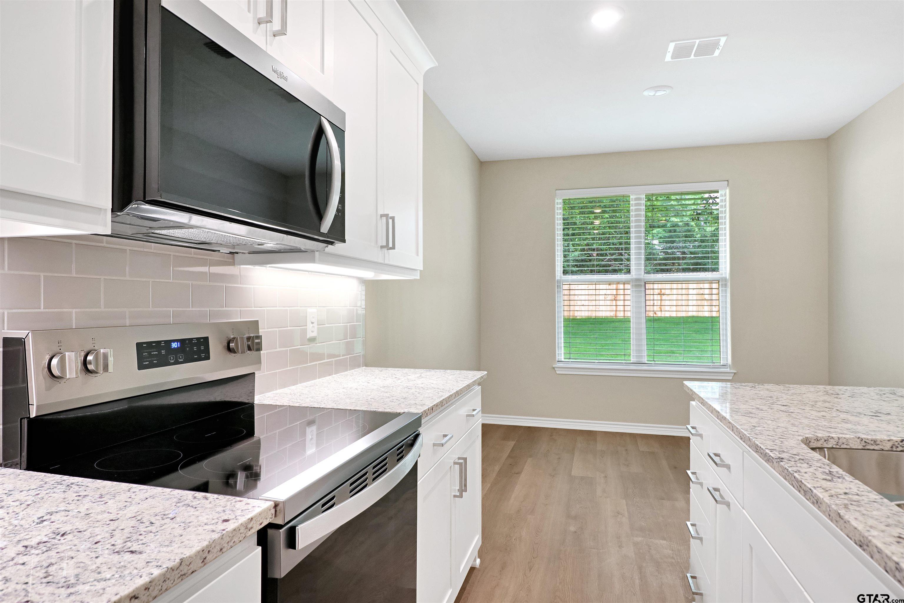 3053 Guinn Farms Road Tyler, TX 75707 - Photo 10 of 32 a kitchen with a stove microwave and sink
