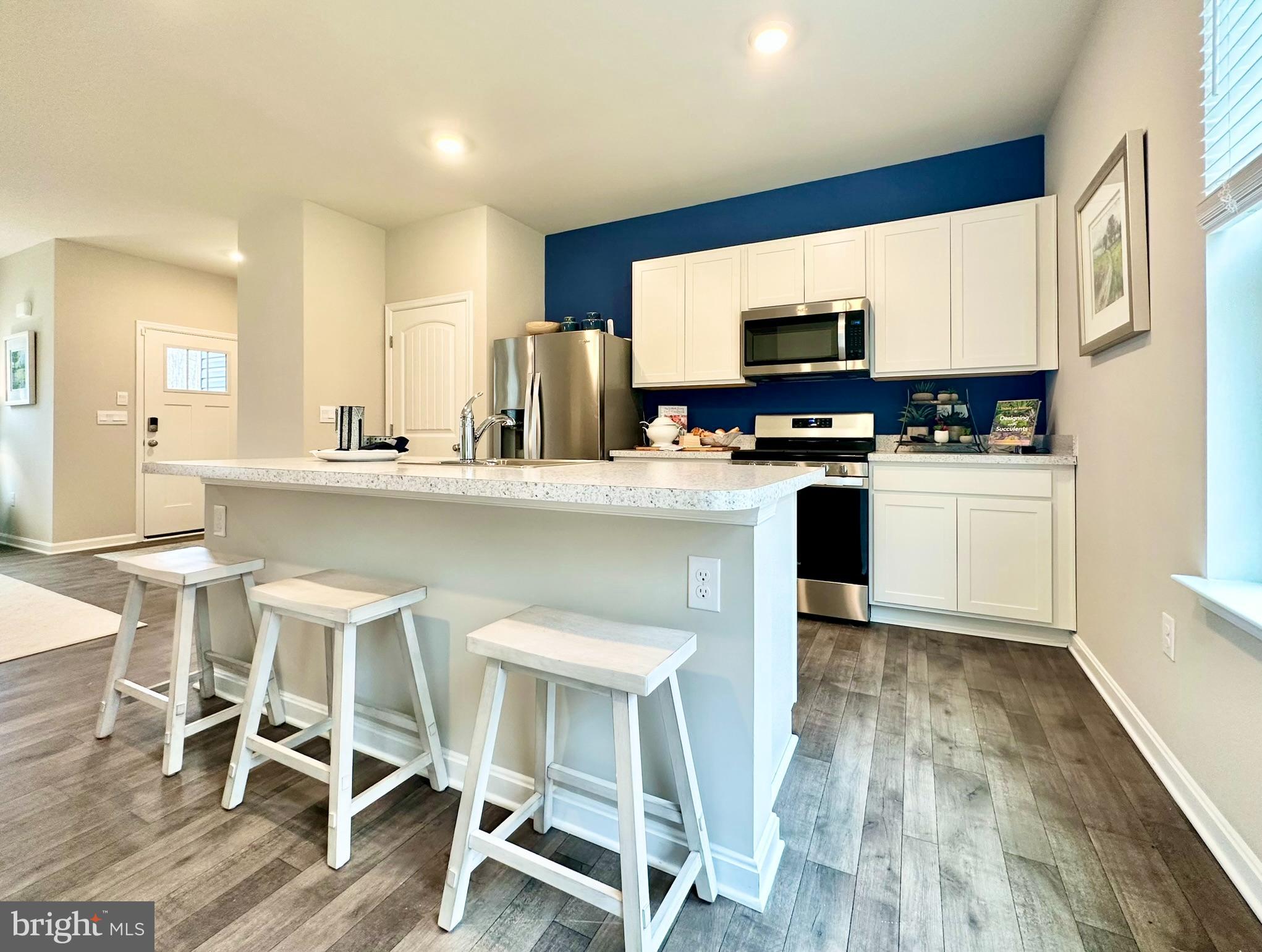 104 Red Haven Way Dover, DE 19904 - Photo 11 of 33 a kitchen with stainless steel appliances granite countertop a table chairs refrigerator and microwave