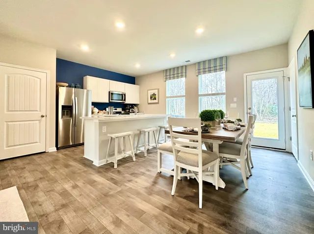 a dining room with furniture a large window and wooden floor
