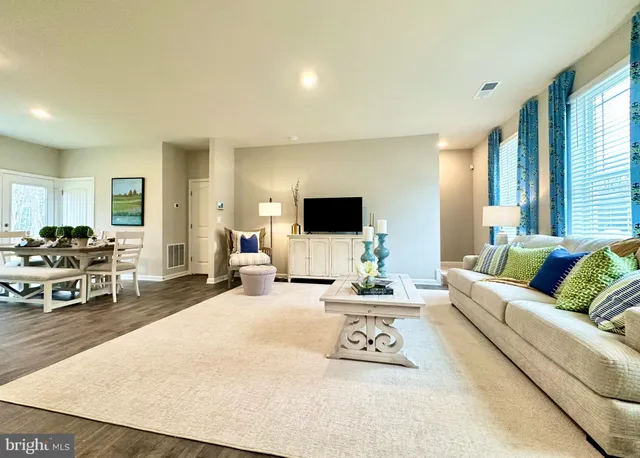 a living room with furniture a flat screen tv and a large window