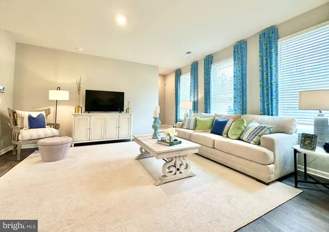 a living room with furniture a flat screen tv and a large window